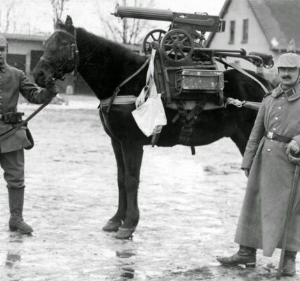 Deutsche Soldaten posieren während des Ersten Weltkriegs mit einem Pferd, auf dem ein erbeutetes Maschinengewehr sitzt