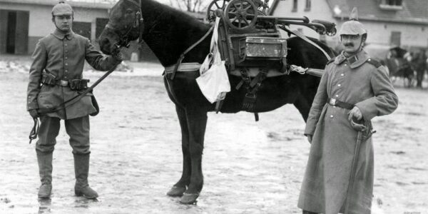 Deutsche Soldaten posieren während des Ersten Weltkriegs mit einem Pferd, auf dem ein erbeutetes Maschinengewehr sitzt