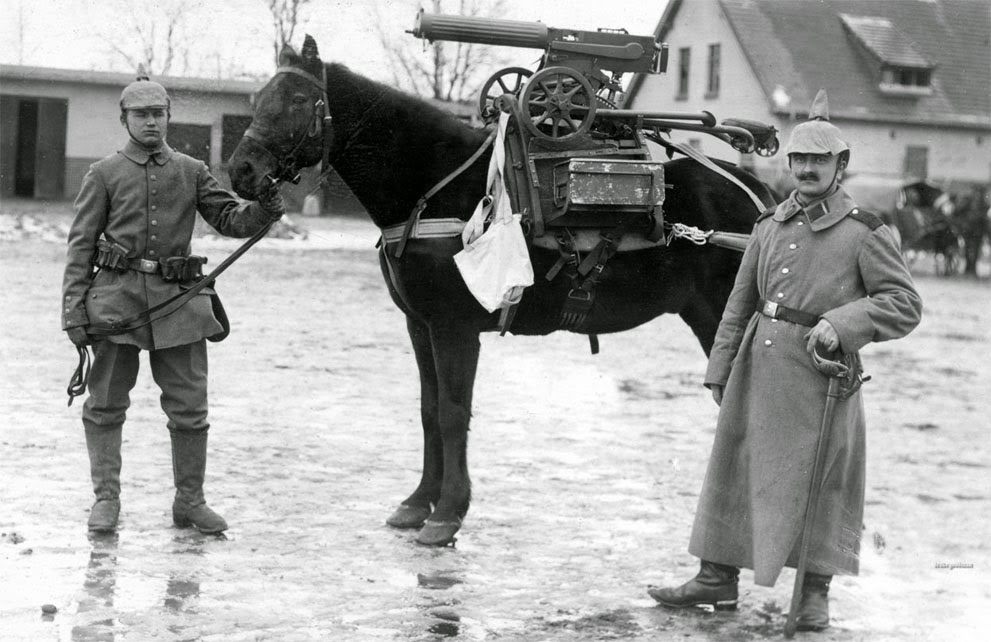 Deutsche Soldaten posieren während des Ersten Weltkriegs mit einem Pferd, auf dem ein erbeutetes Maschinengewehr sitzt